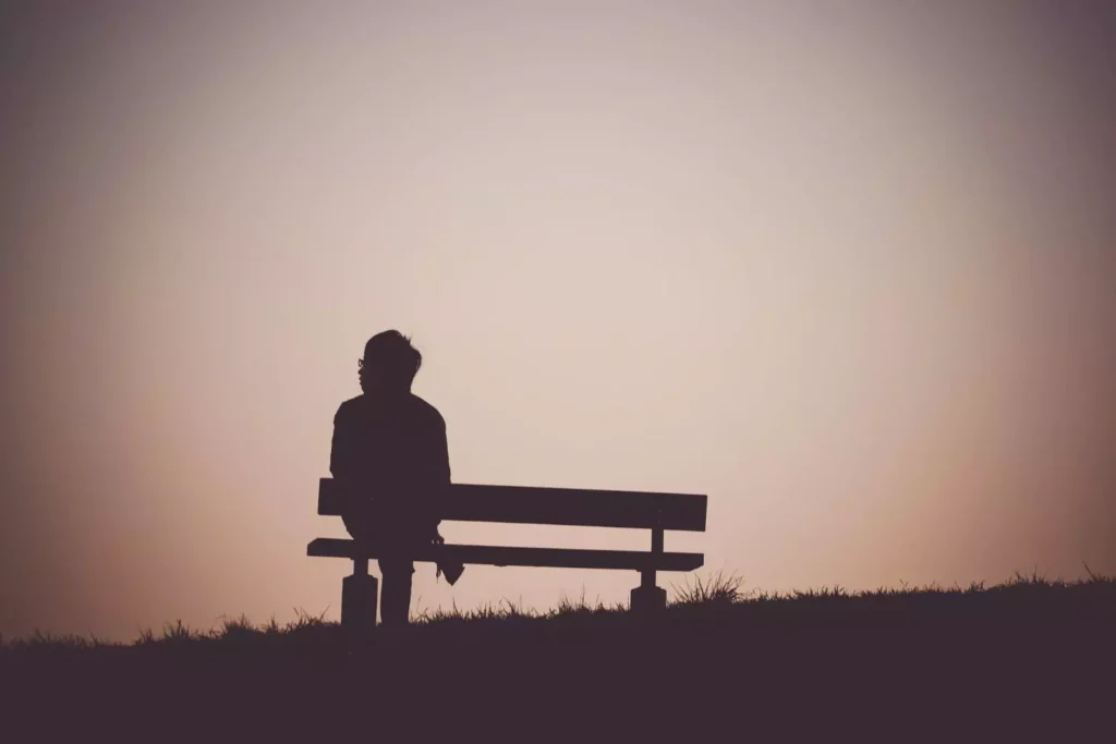 a person in despair sitting on a bench