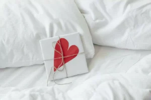 a letter with a heart on it, lying on a bed, tied with a string - a symbol that one should not engaged in premarital sex