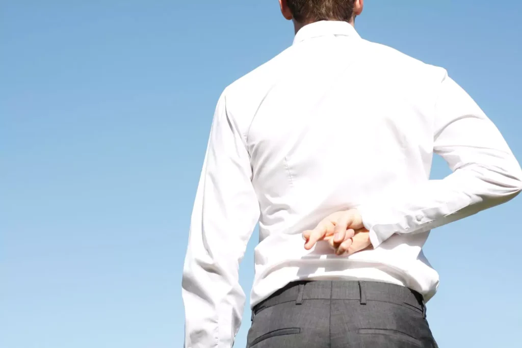a man crossing his fingers behind his back, a hypocrite