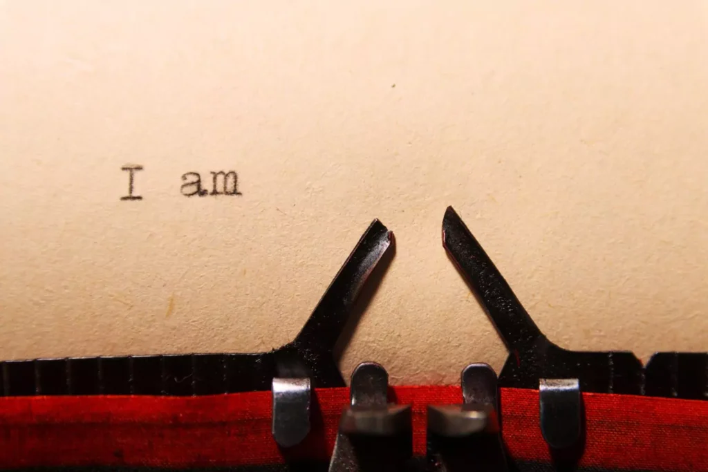 a typewriter, typing out the phrase "I am..."; seeking vulnerability