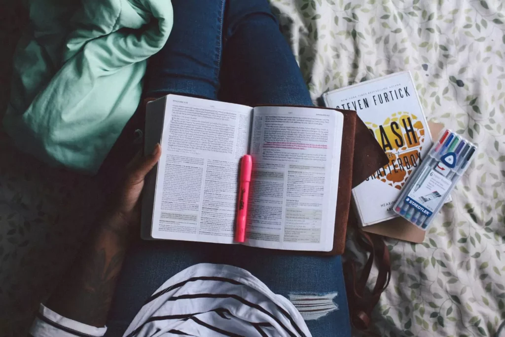 a person with reading their Bible opened in their lap