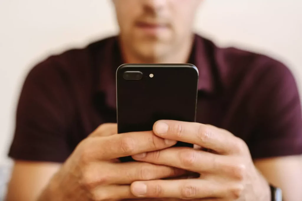 a man looking at his iPhone
