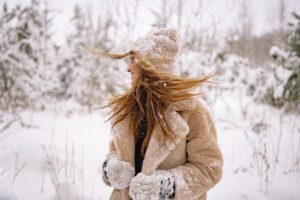 a woman standing in the snow, warding off the holiday loneliness