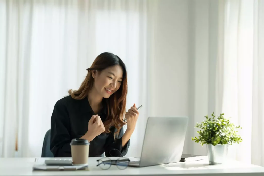 a woman smiling at her computer - she's working to stay marketable in her 30s