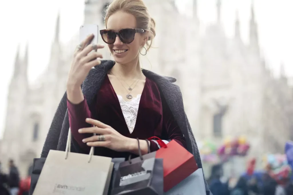a woman holding a lot of shopping bags, having let the lifestyle creep settle in