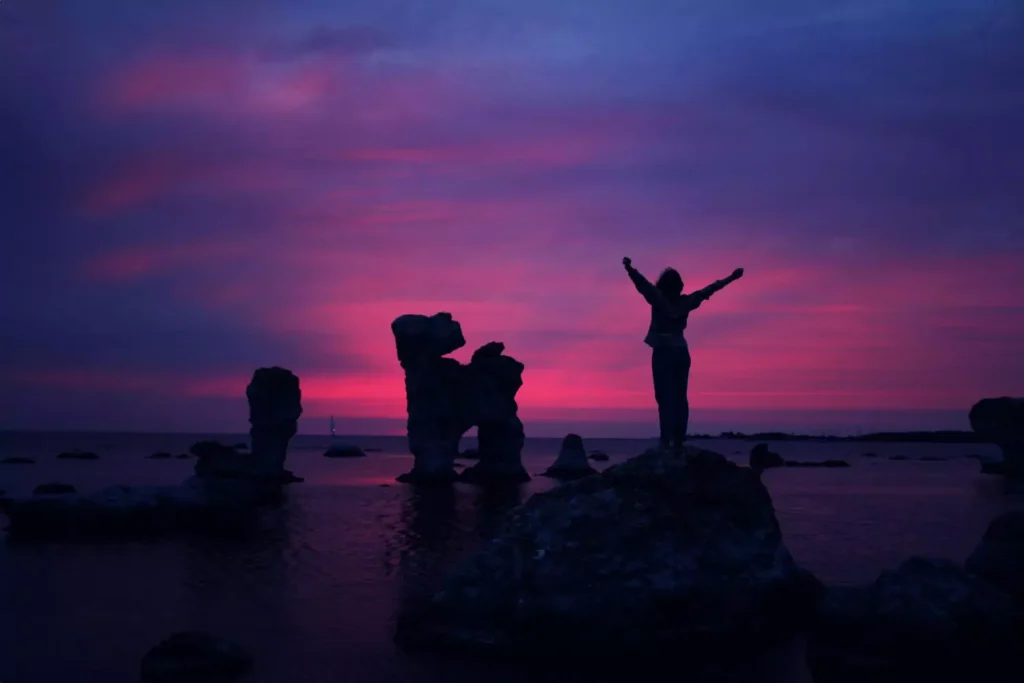 a silhouette of a woman in front of a pink and blue sky, celebrating her sexuality