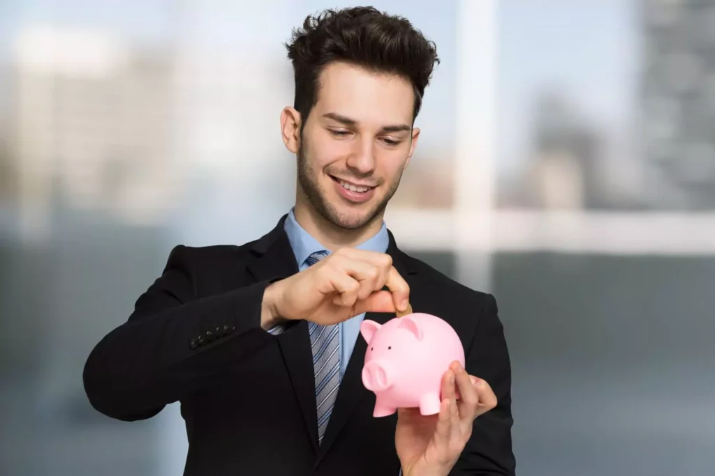 a man making financial progress by putting money in a piggy bank