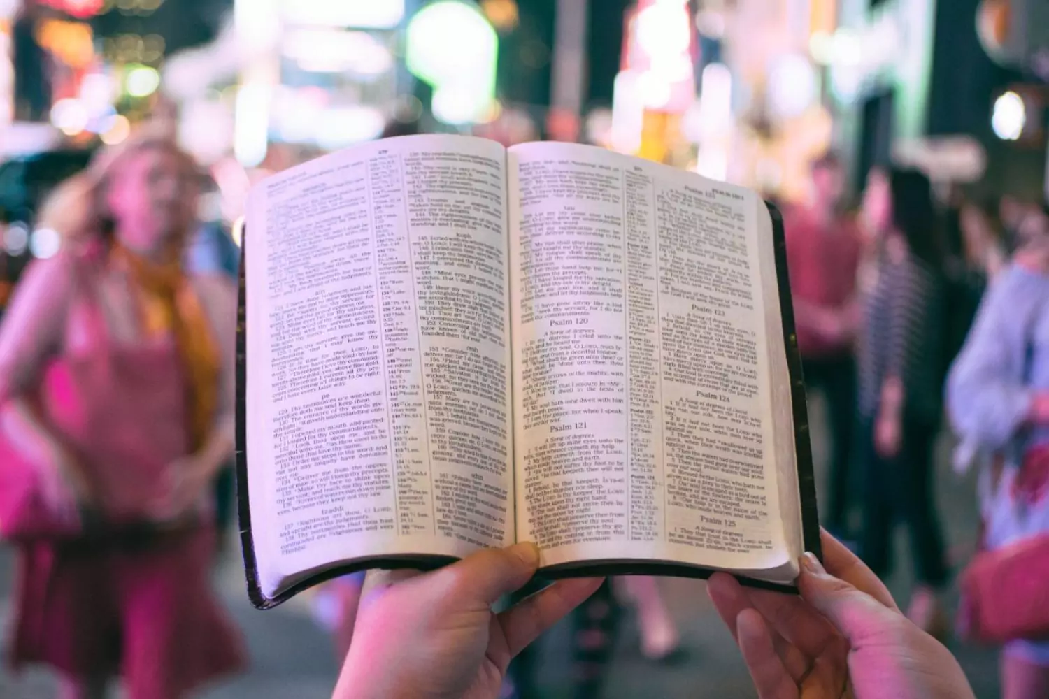 a person reading a Bible in a city, reading Scripture and overcoming lust