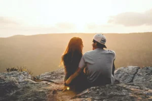 a couple sitting on a rock talking about their spouse checklists