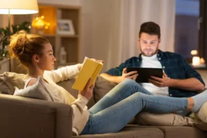 a boring couple sitting on the couch reading