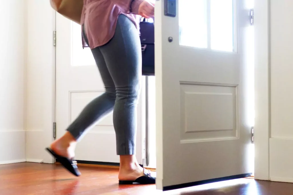 a woman walking out of the door to her parent's house, ready to launch