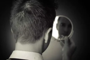 a man looking at himself in the mirror, thinking about being too picky when it comes to choosing a wife