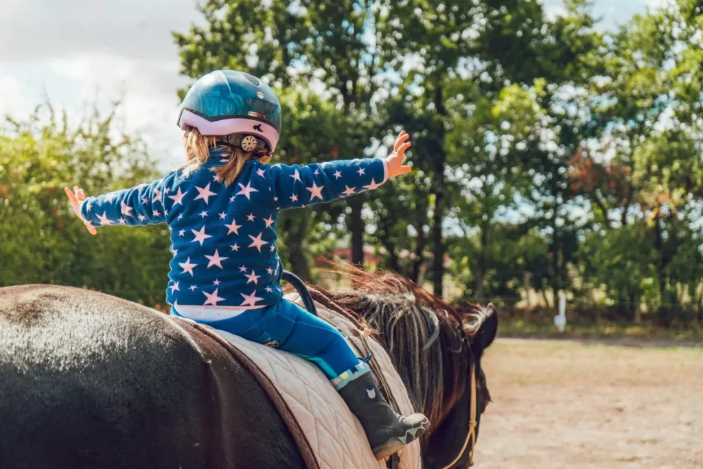 a young girl riding a horse with courage