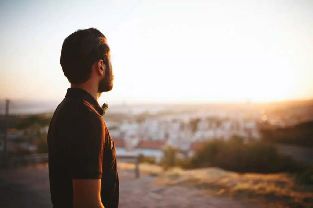 a young man looking at a sunset thinking about Jesus in His 20s