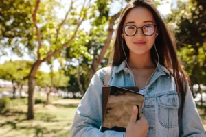 a woman holding books on a college campus