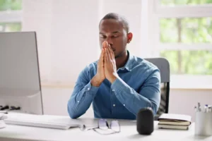 a man praying at his desk at work