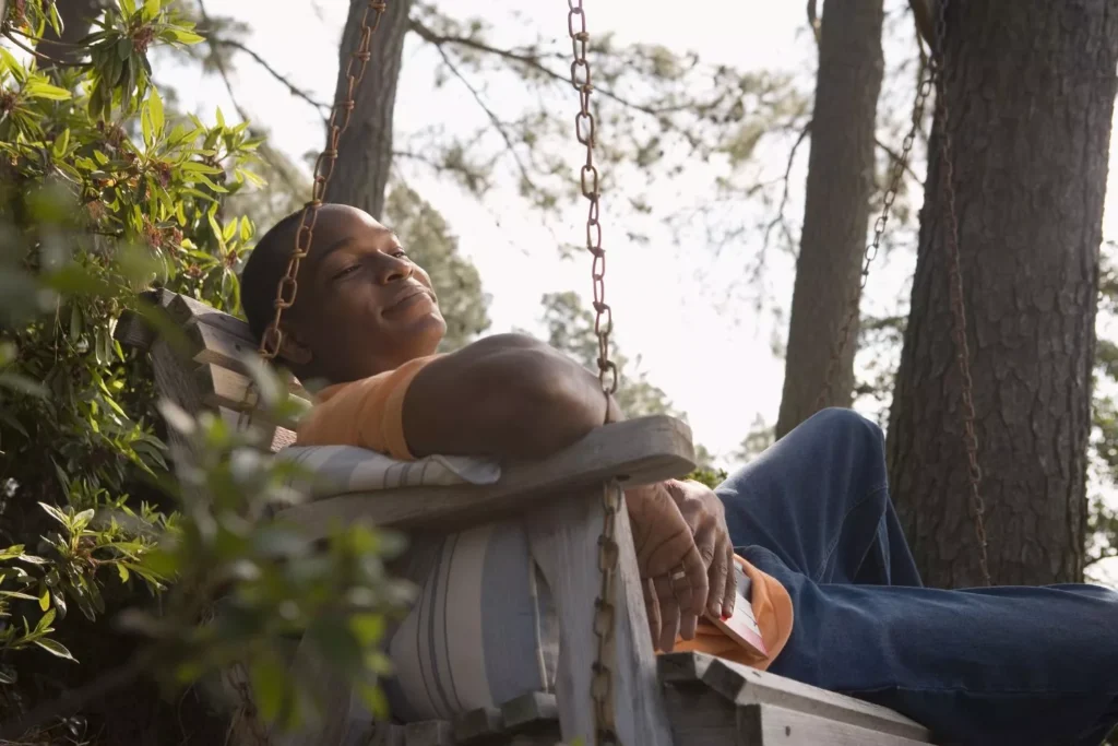 a man resting on a porch swing